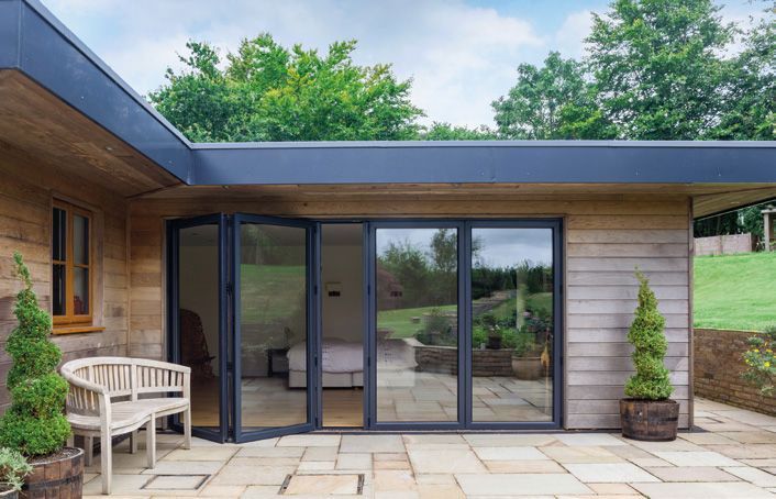 A house with a patio and sliding glass doors leading to a bedroom.