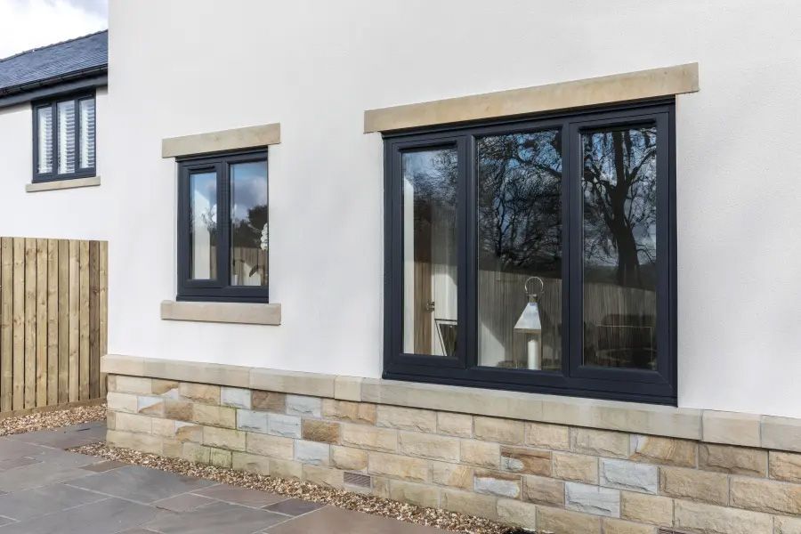 There are two windows on the side of a house.