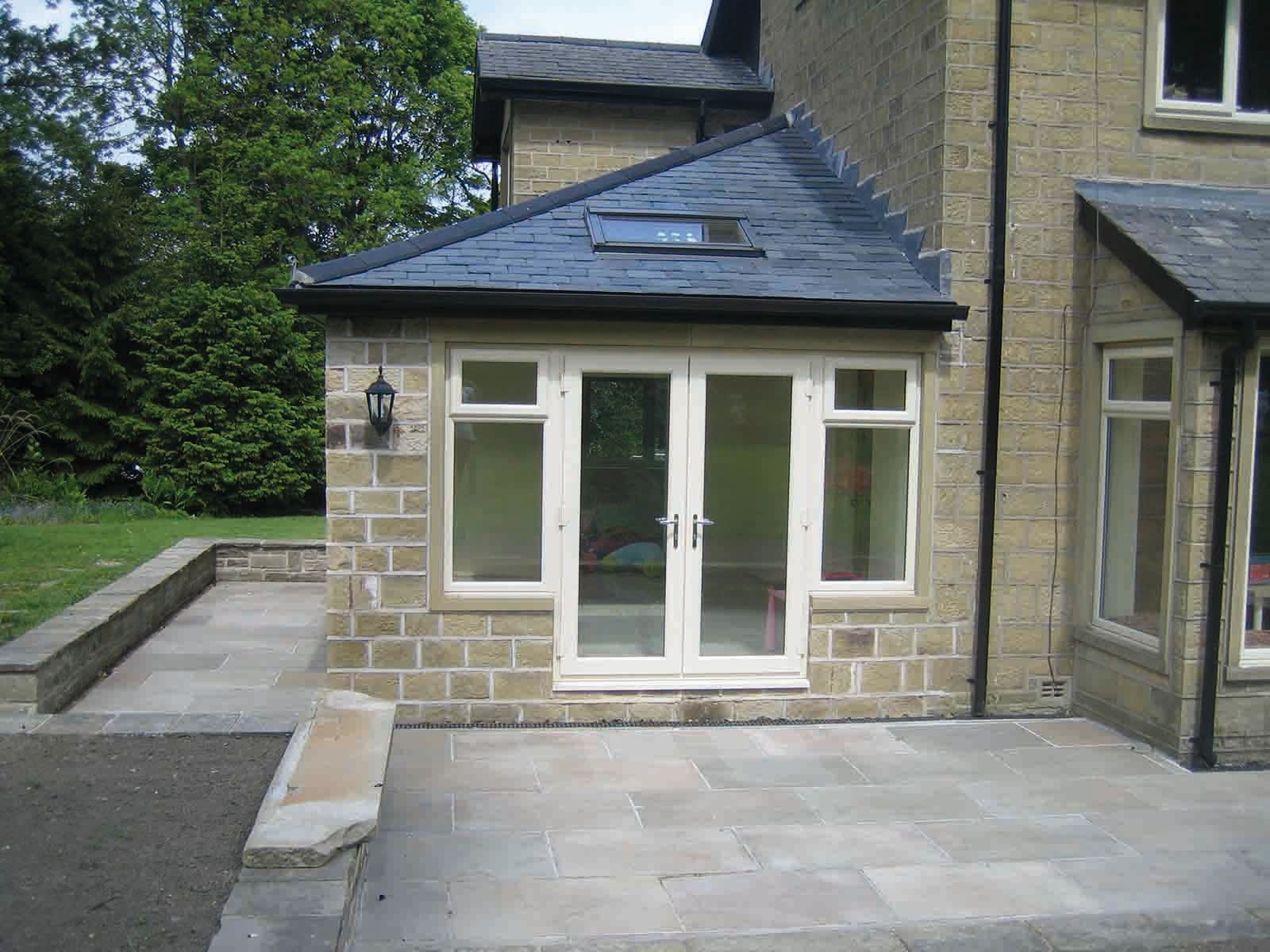 A brick house with a slate roof and a patio