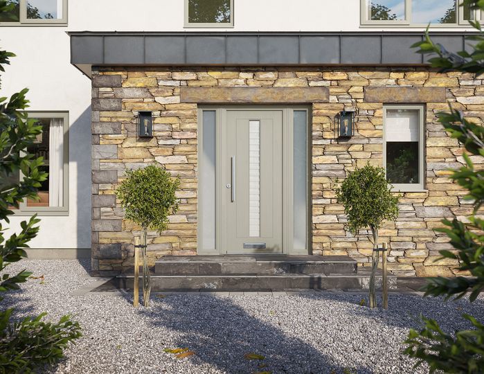 The front door of a house with a stone wall and a gray door.
