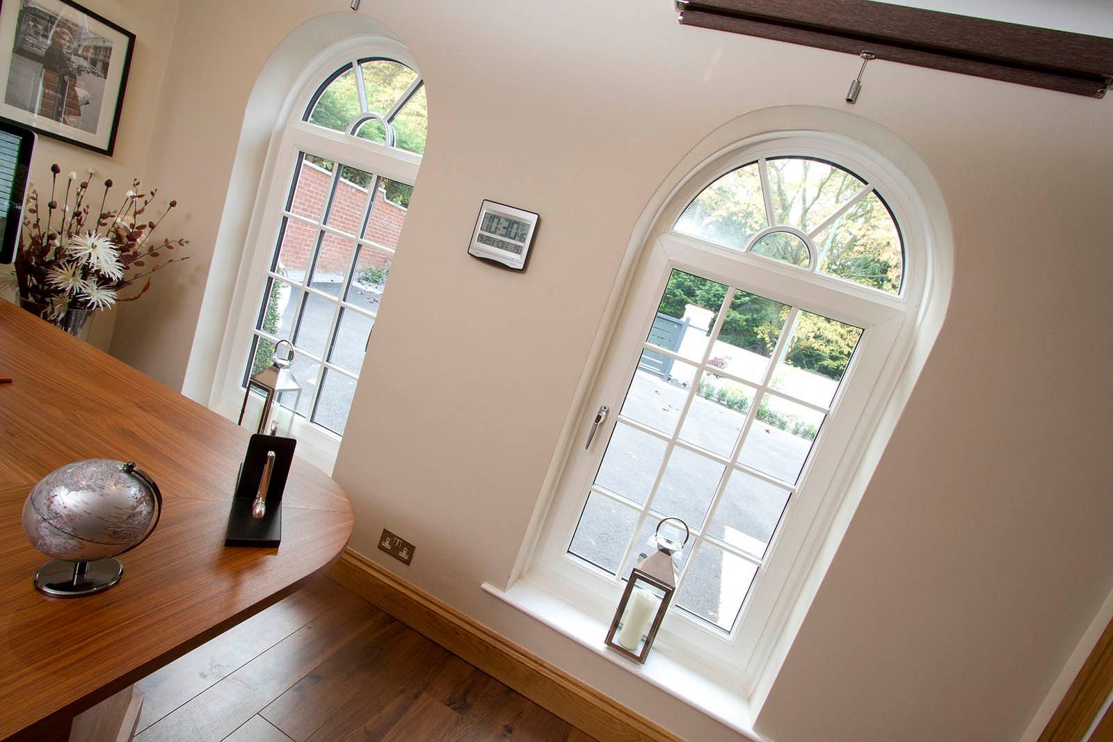 A room with two arched windows and a wooden table
