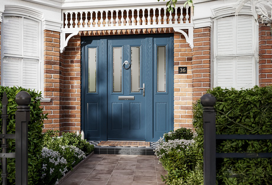 A blue door is on the front of a brick house.