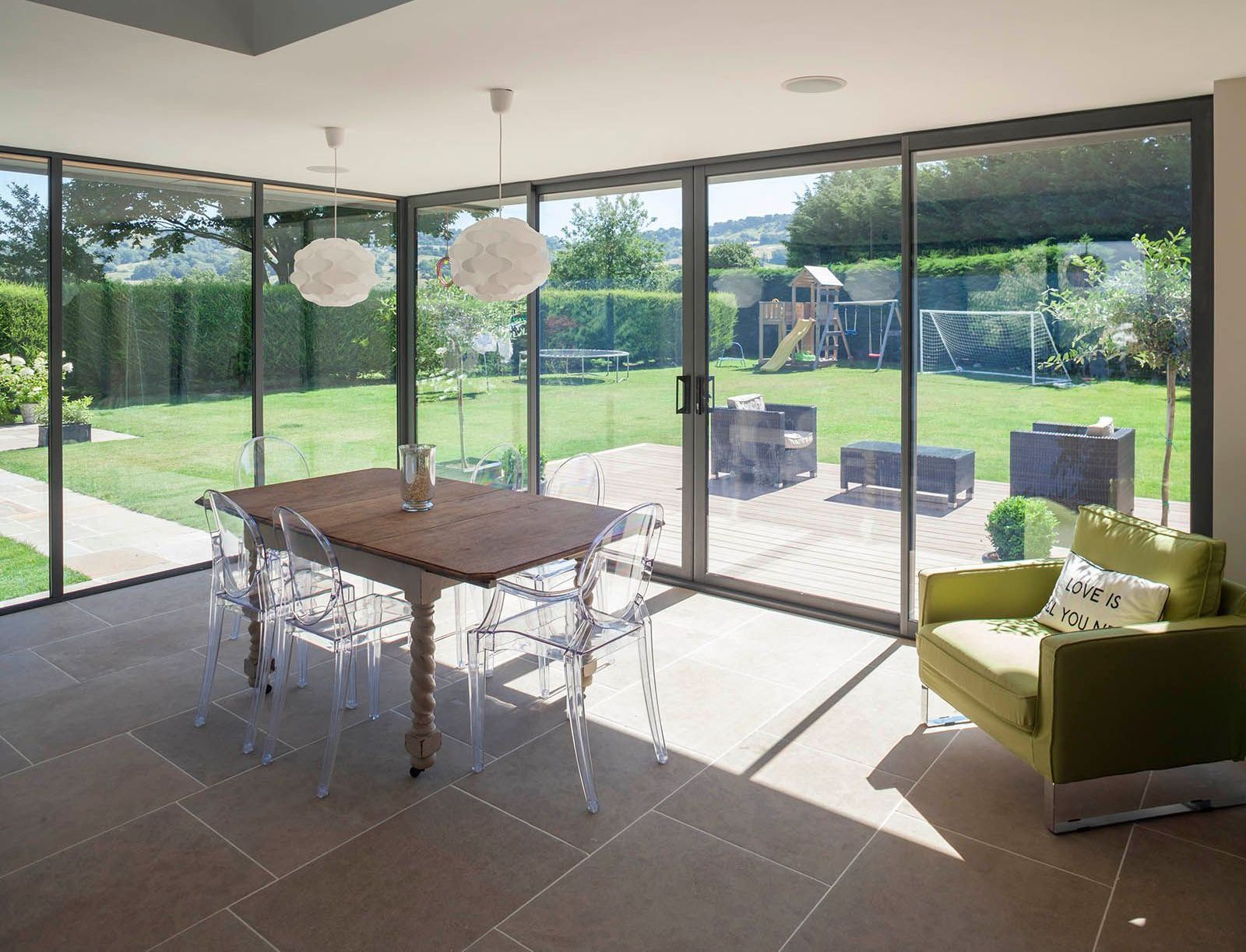 A dining room with a table and chairs and sliding glass doors leading to a backyard.