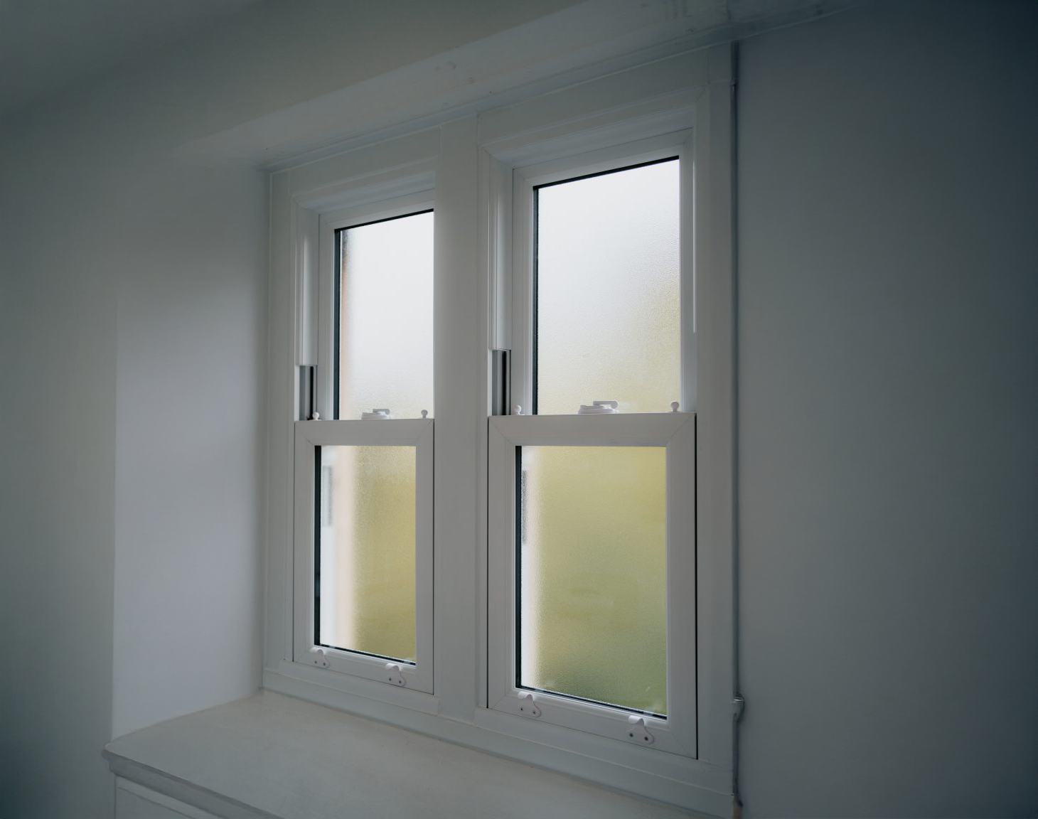 A white window with frosted glass in a room