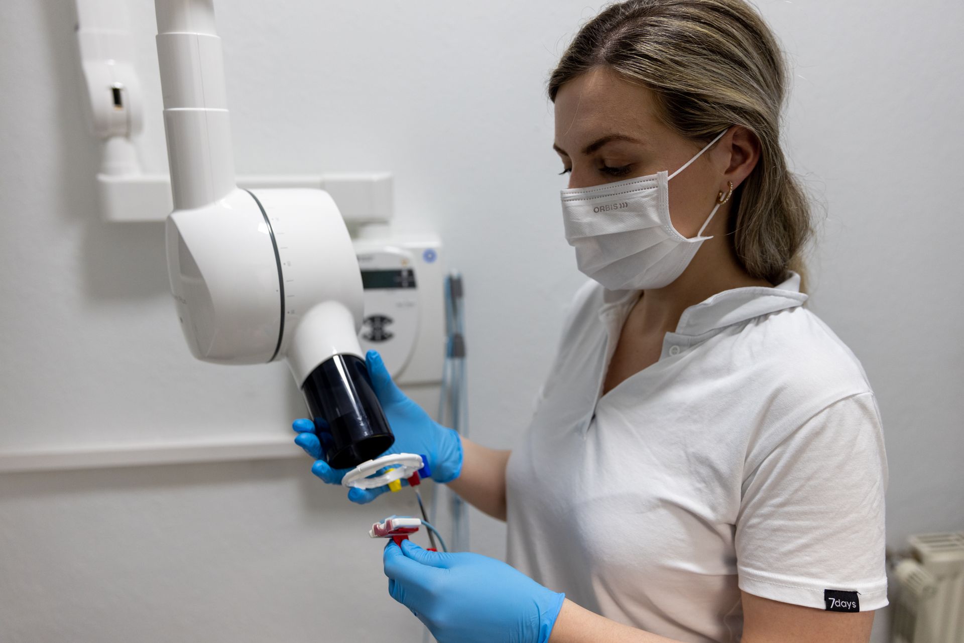 Eine Zahnärztin mit Maske und blauen Handschuhen, Zahnarztpraxis Enny Lohse.de