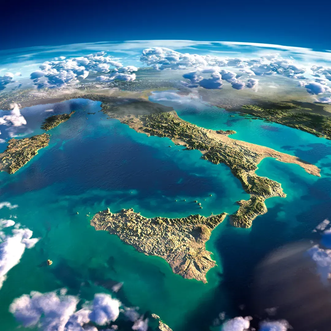 Luftaufnahme einer türkisfarbenen Inselküste mit weißen Wolken und tiefblauem Meer unter einem geschwungenen Horizont