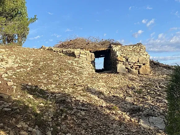 Un edificio de piedra con un agujero en el medio en la cima de una colina.