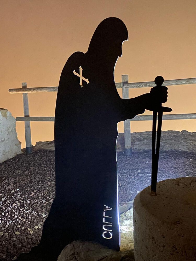 Una silueta de un hombre con una cruz en la espalda.