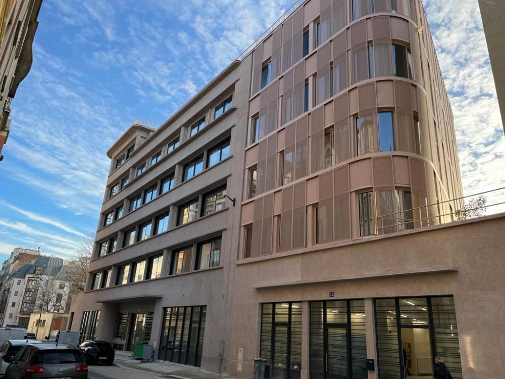 Immeuble résidentiel moderne avec de grandes fenêtres, dans une rue en ville sous un ciel bleu