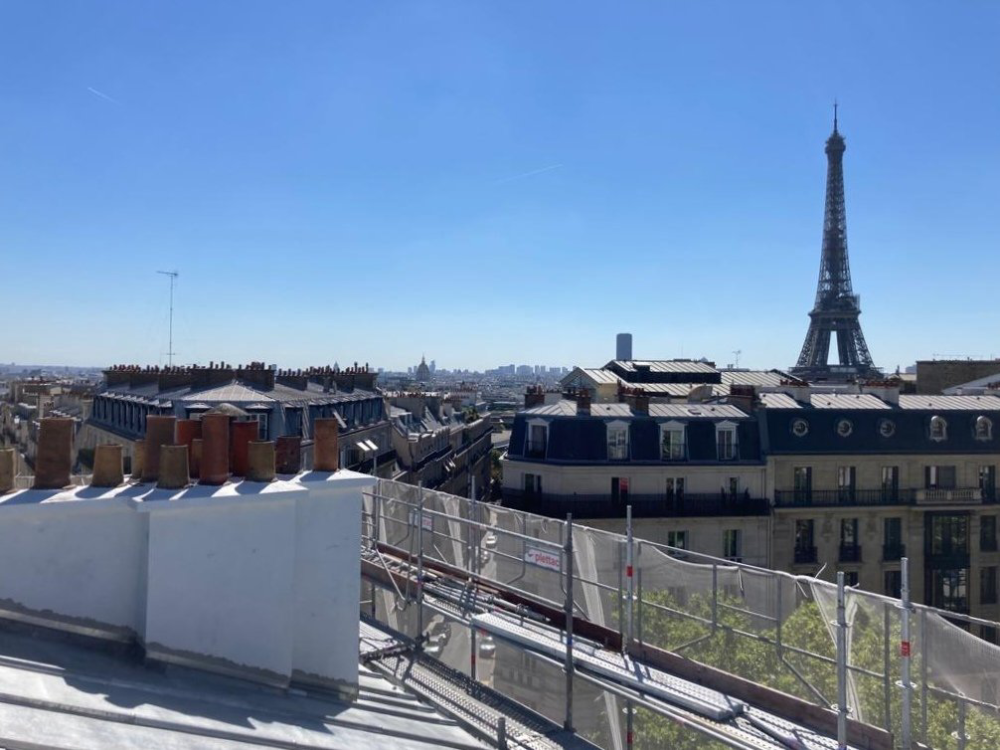 Vue sur les toits de Paris avec la tour Eiffel sous un ciel bleu dégagé
