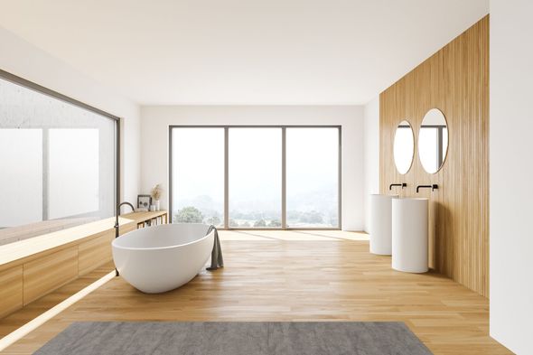 Un baño con bañera, lavabo y un gran ventanal.
