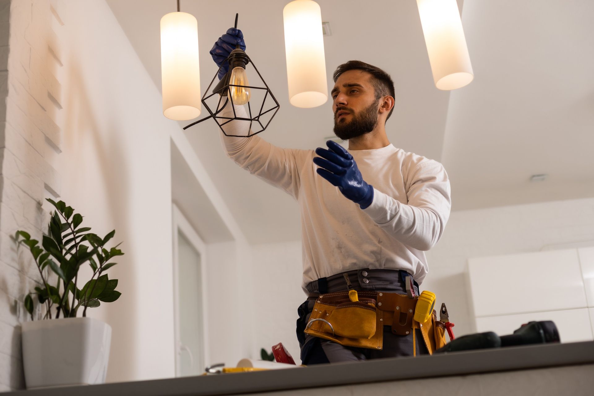 Un hombre está arreglando una lámpara en una sala de estar.
