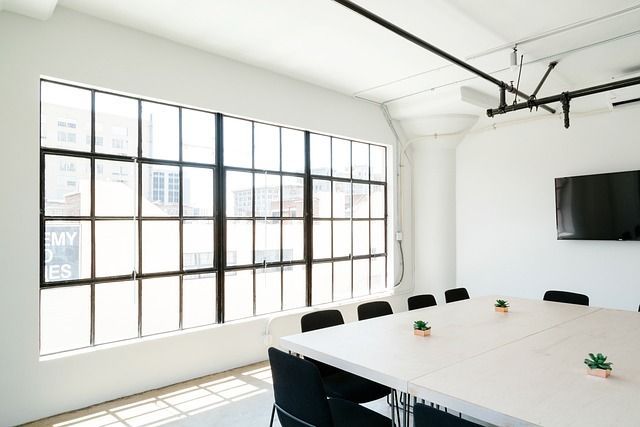 Una sala de conferencias con una mesa larga y sillas y una ventana grande.
