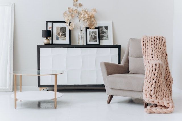 Una sala de estar con una silla, una mesa de café y una cómoda.