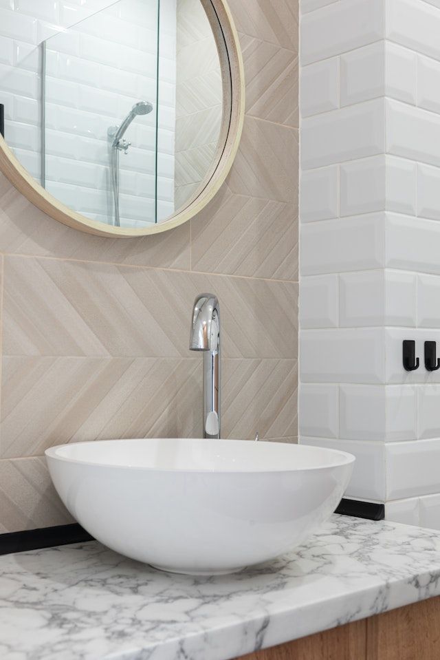 Un baño con lavabo, espejo y ducha.