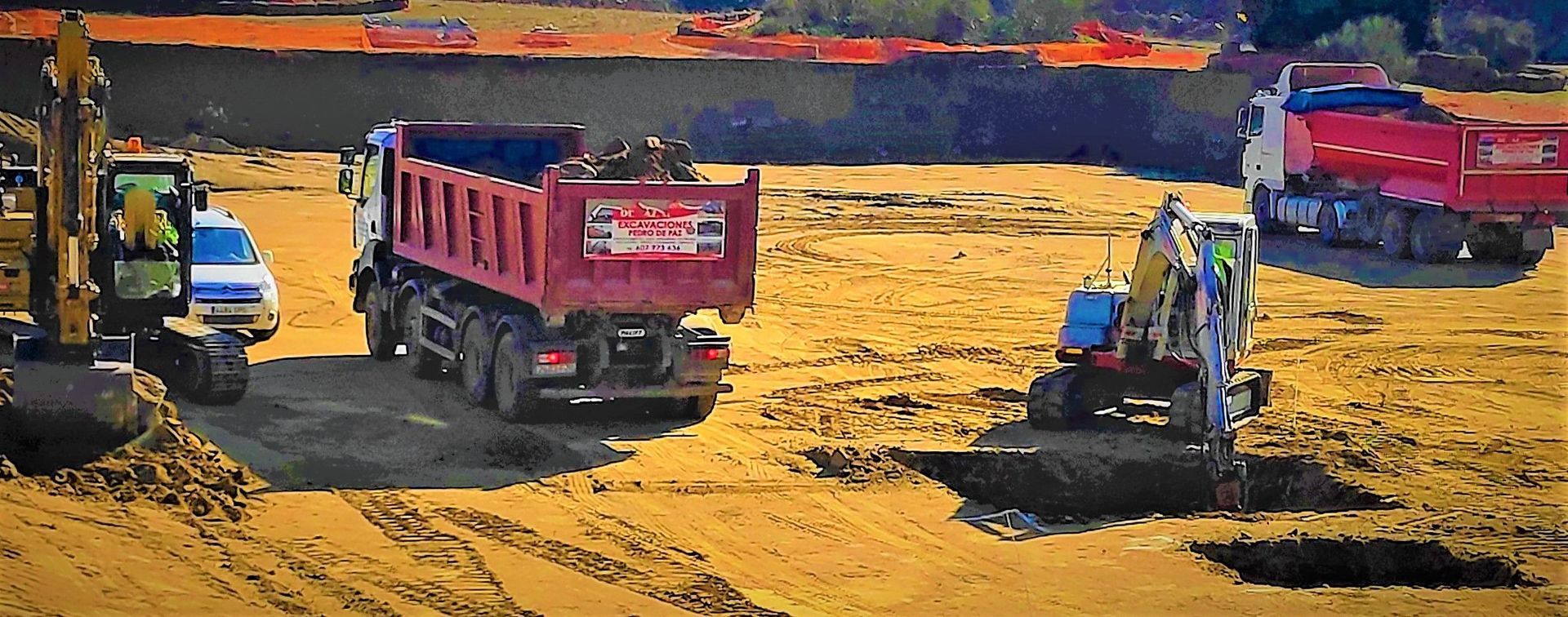 Sitio de construcción con excavadoras y camiones de volteo cargando tierra.