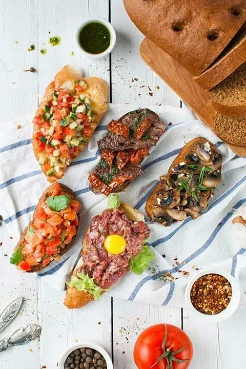 Hay muchos tipos diferentes de sándwiches en la mesa.