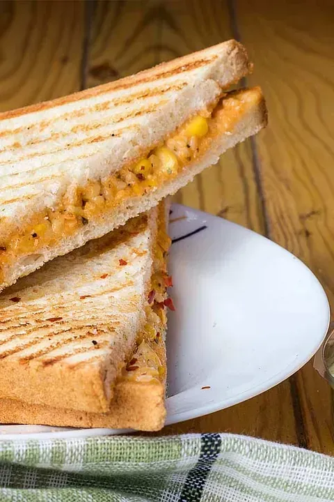Un primer plano de un sándwich en un plato sobre una mesa de madera.