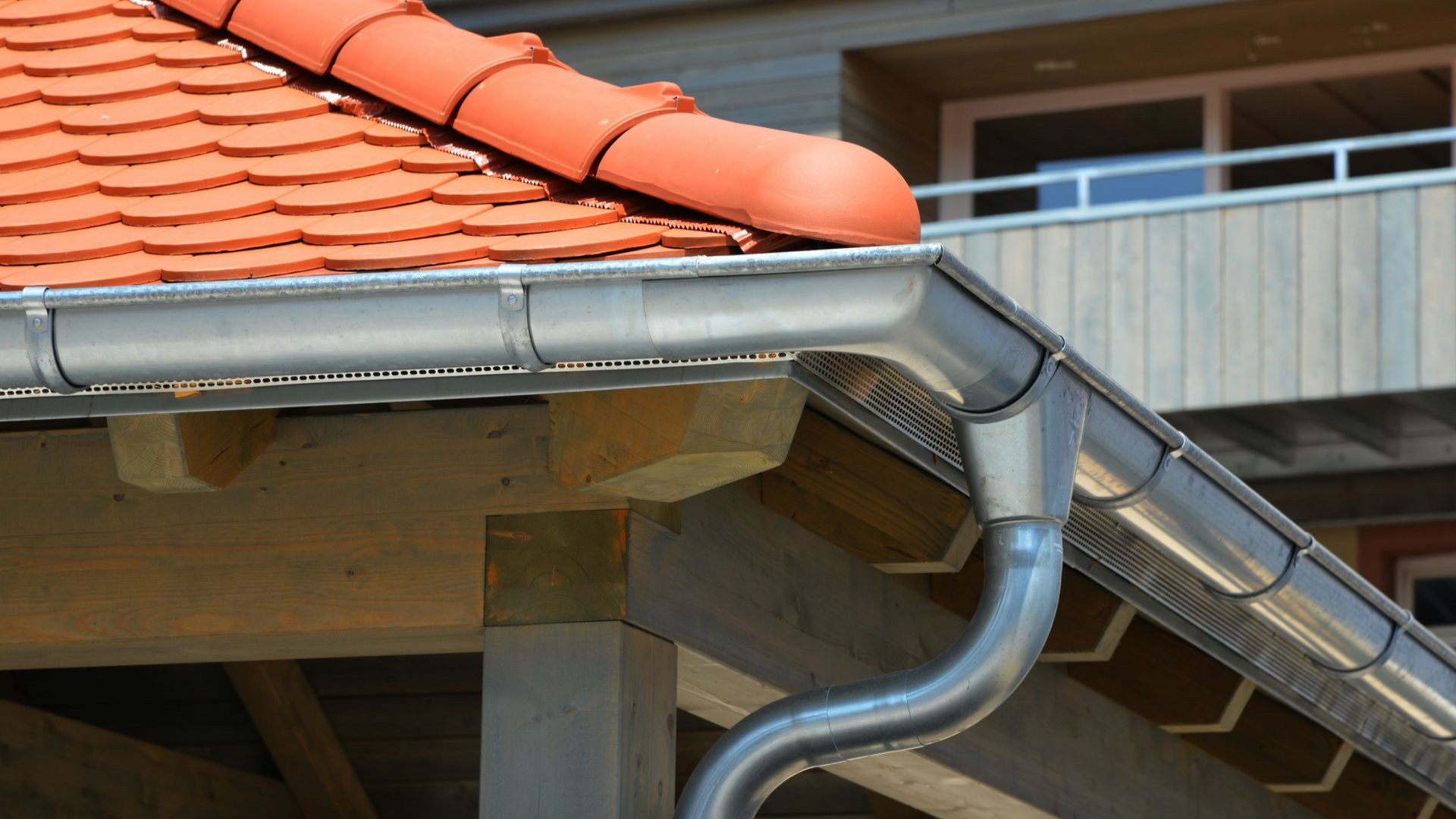 Intérieur d'un grenier avec une porte blanche ouverte, un escabeau jaune et des poutres en bois apparentes.