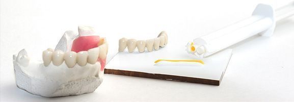 Modelo dental con dentaduras postizas y herramientas dentales.