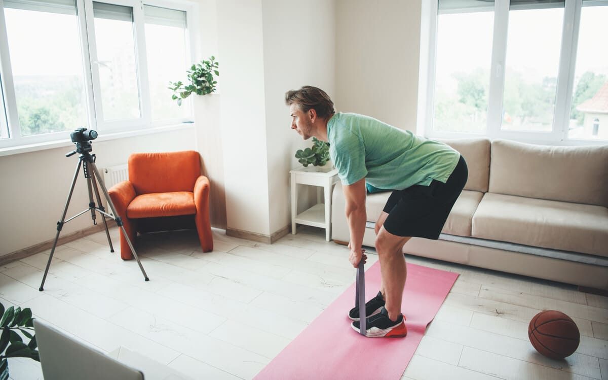 Un hombre va en bicicleta por una carretera al atardecer.