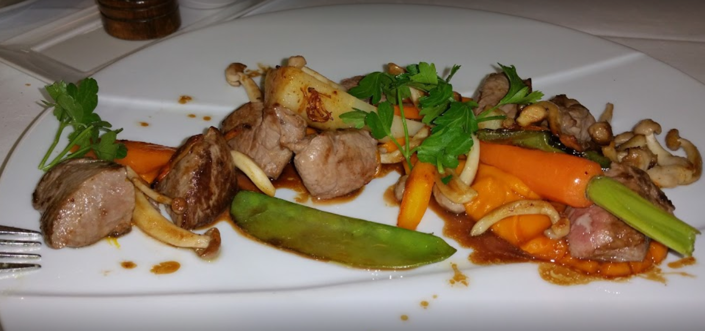 Assiette de viande cuite avec légumes et sauce.