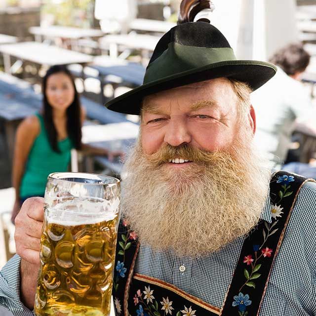 a man with a beard is holding a glass of beer