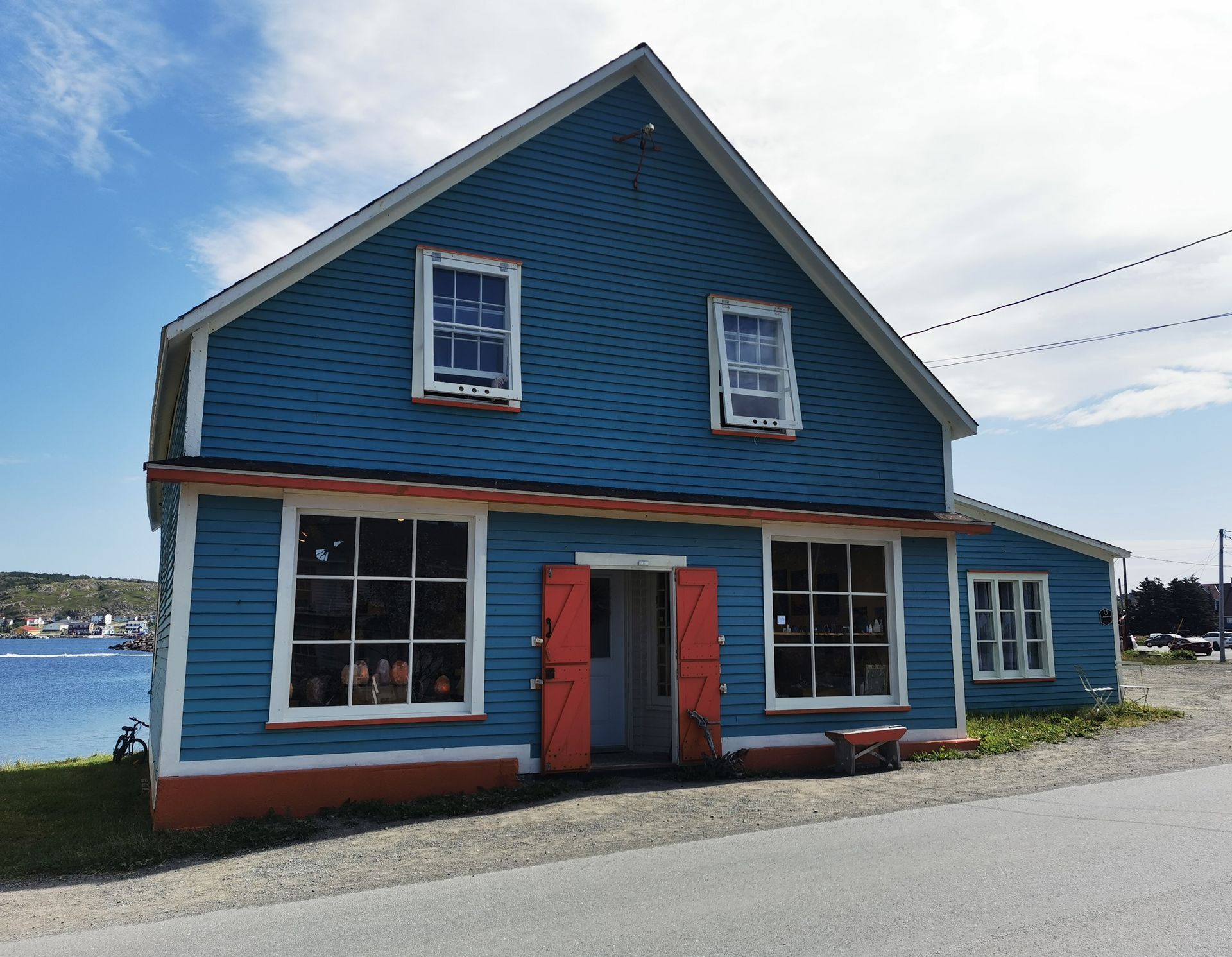 A blue building with a white roof and red doors