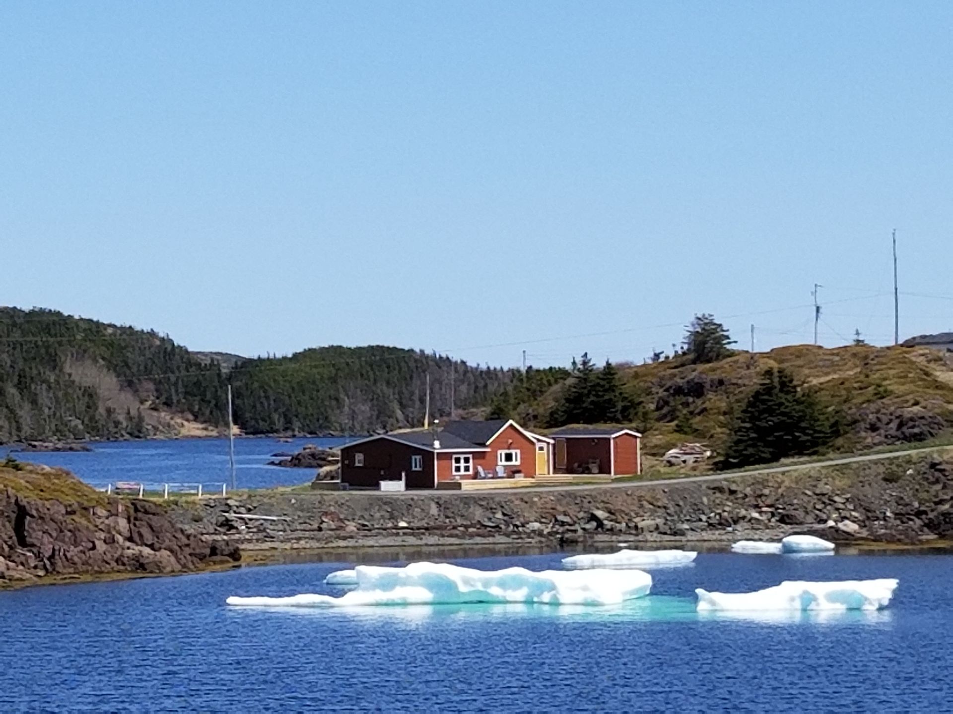 A red house sits overlooking a body of water