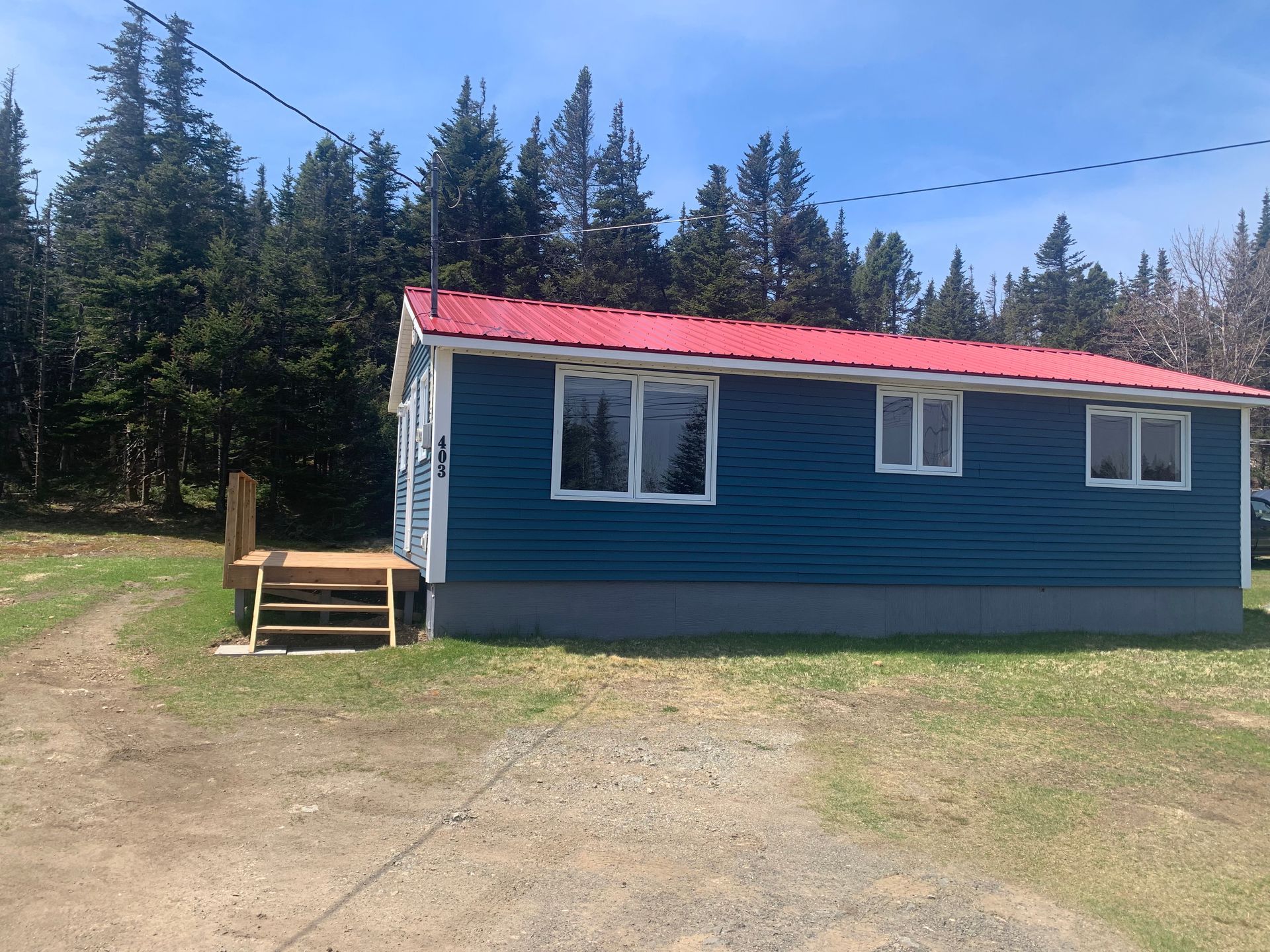 A small blue house with a red roof and white trim.