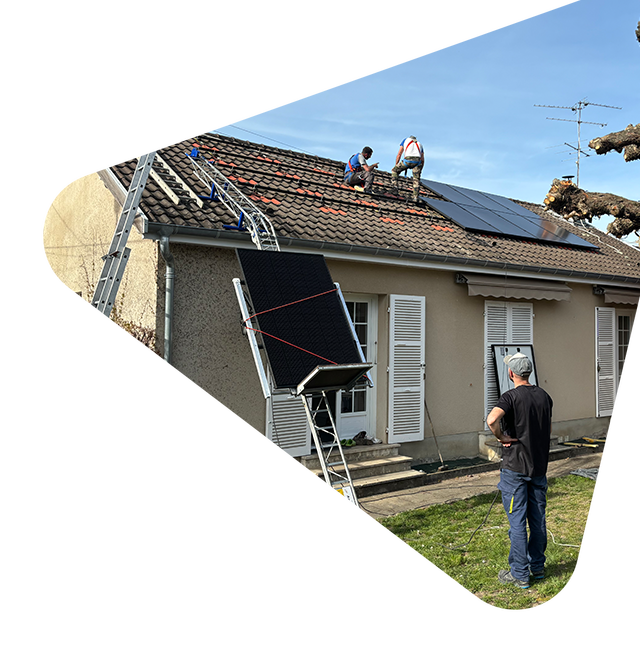 Des ouvriers réparent le toit d'une maison beige, sur laquelle sont installés des panneaux solaires.