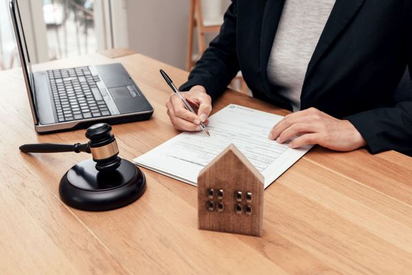 Bureau avec un ordinateur, un marteau de justice et une maison miniature