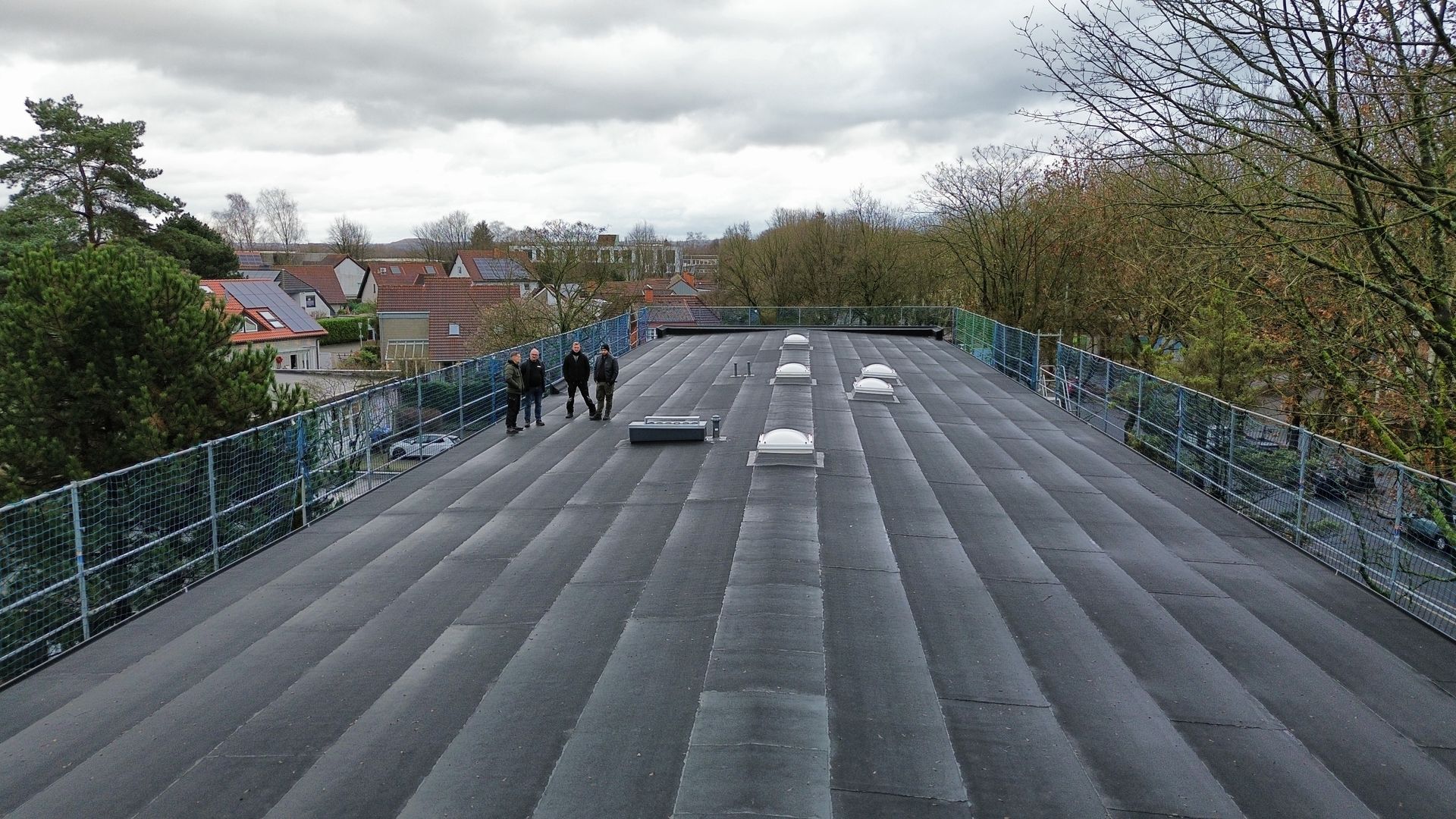 Dachdecker-Team auf einem neu eingedeckten Flachdach