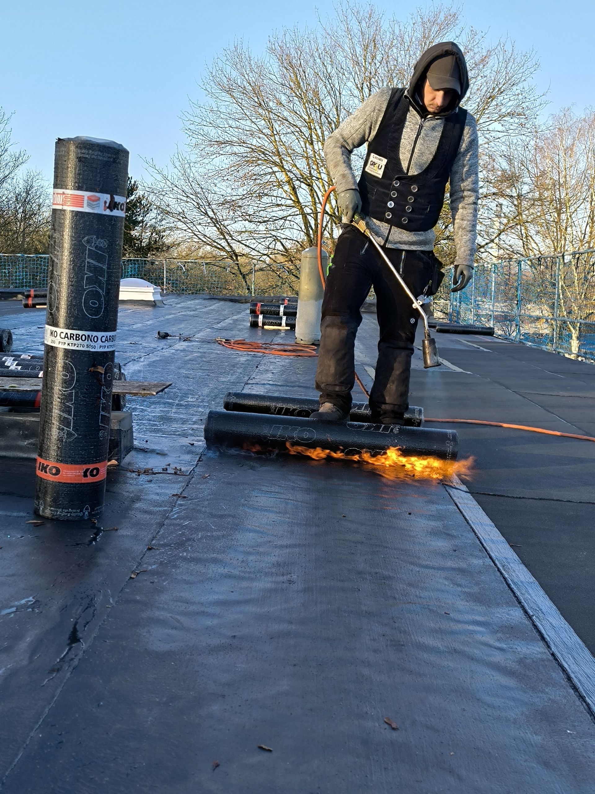 Dachdecker beim Abdichten eines Flachdaches mit Bitumen