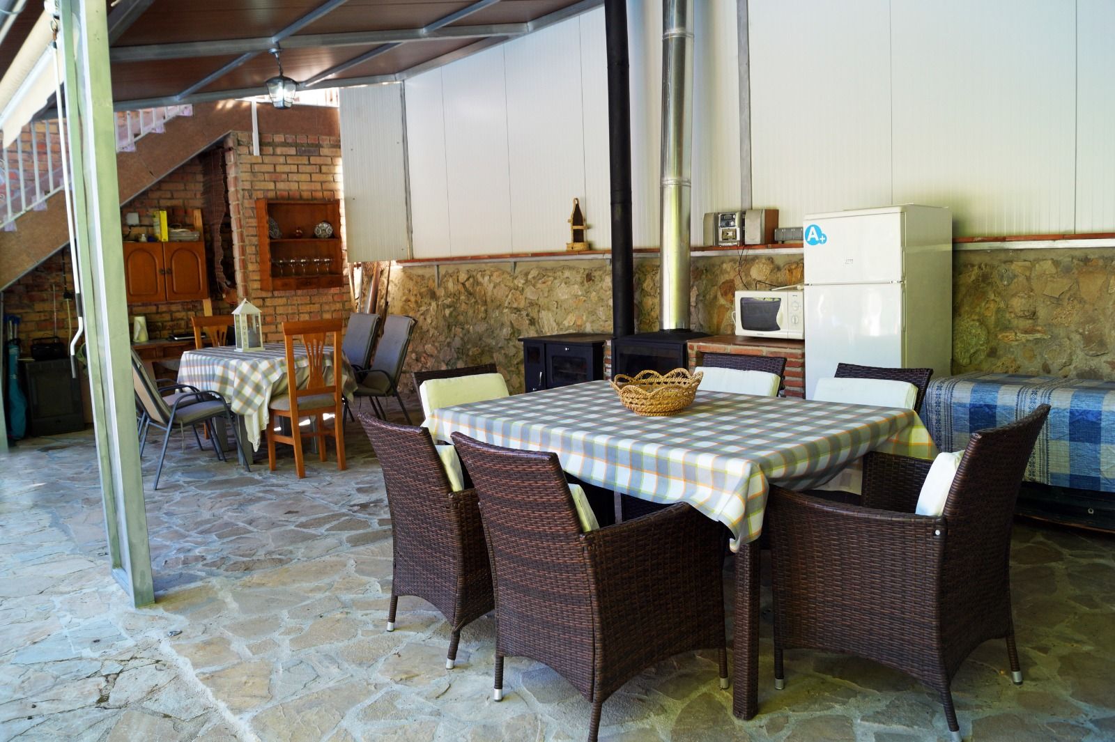 Un patio con mesa y sillas y un refrigerador.