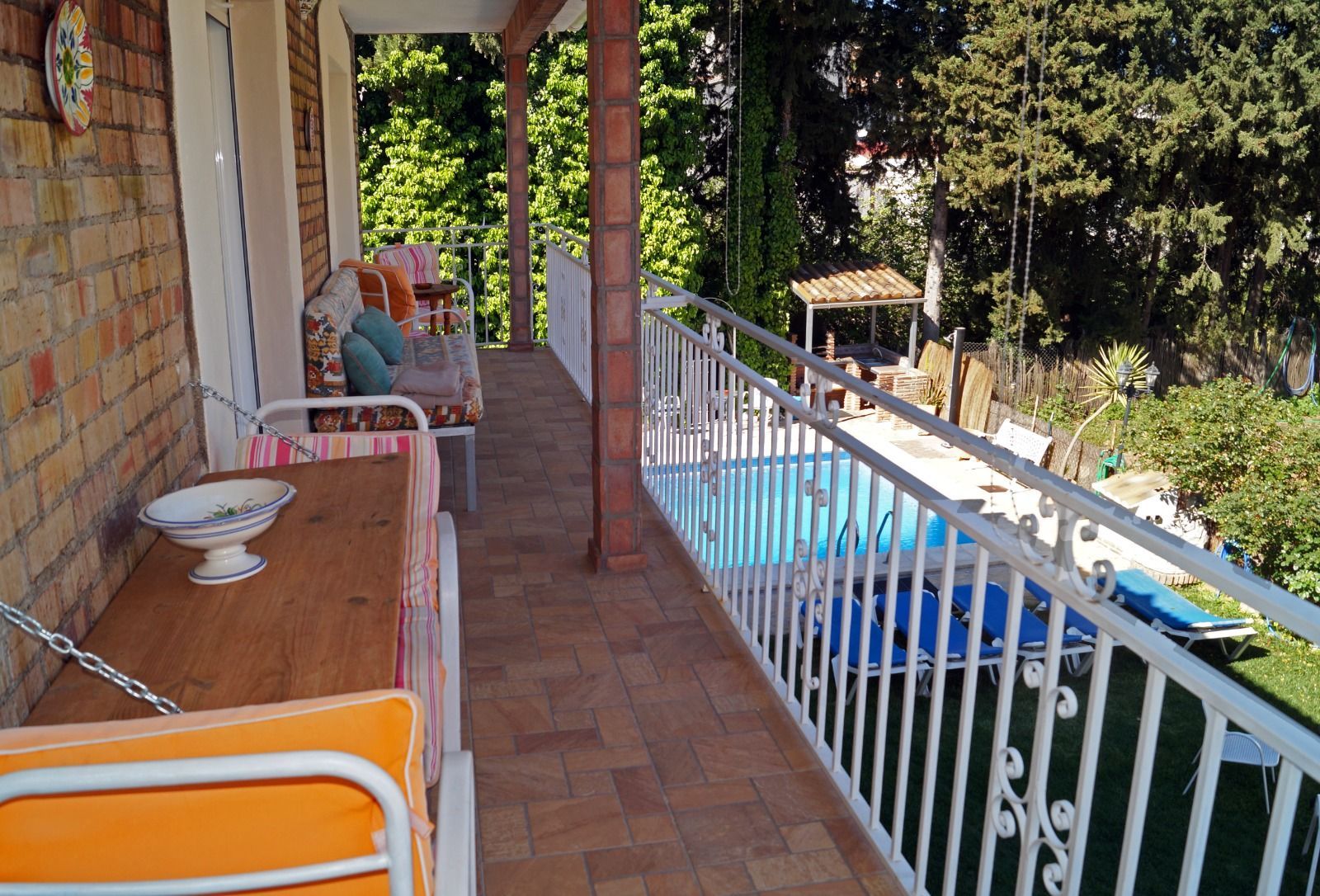 Un balcón con mesa y sillas con vista a una piscina.
