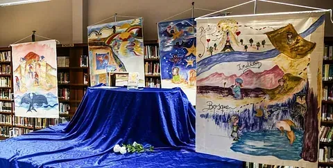 Un grupo de pinturas están expuestas en una biblioteca.