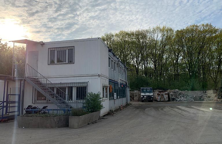 Ein großes weißes Gebäude mit Treppen, die nach oben führen, ist von Bäumen umgeben.