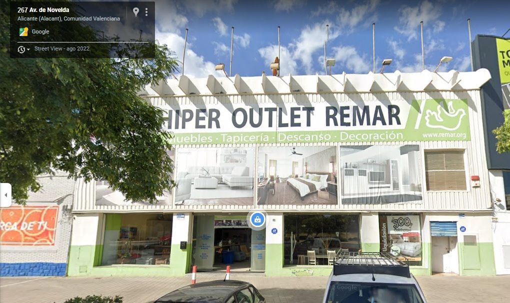 Un coche está aparcado delante de una tienda llamada hiper outlet remar.