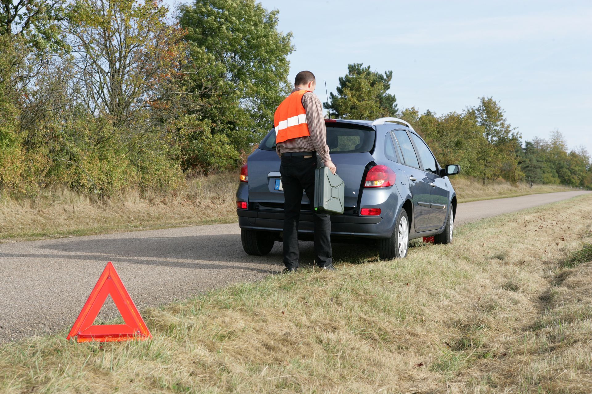 Clio grise en panne garée sur le côté de la route