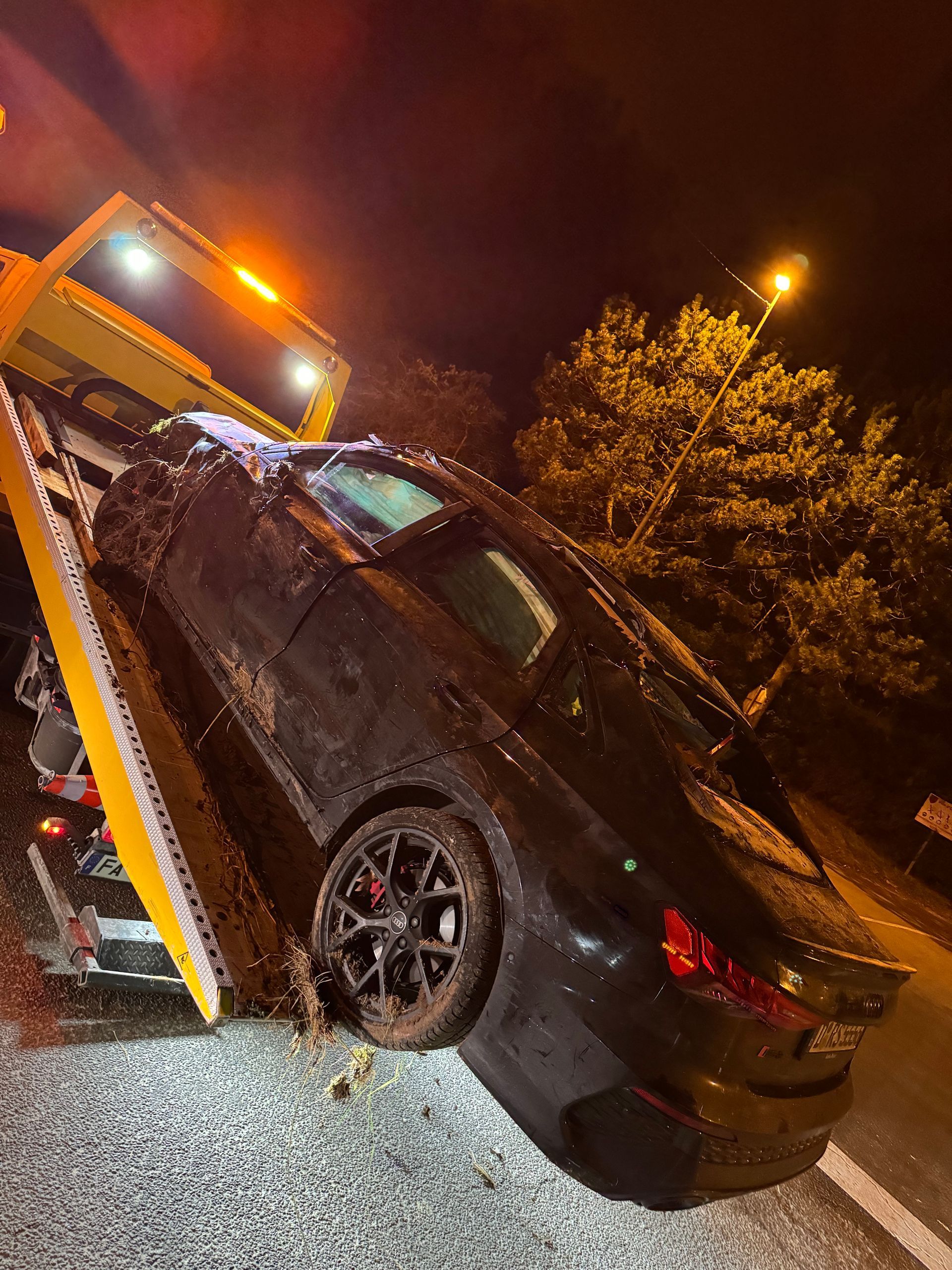 Épave noire accidentée sur un camion de remorquage