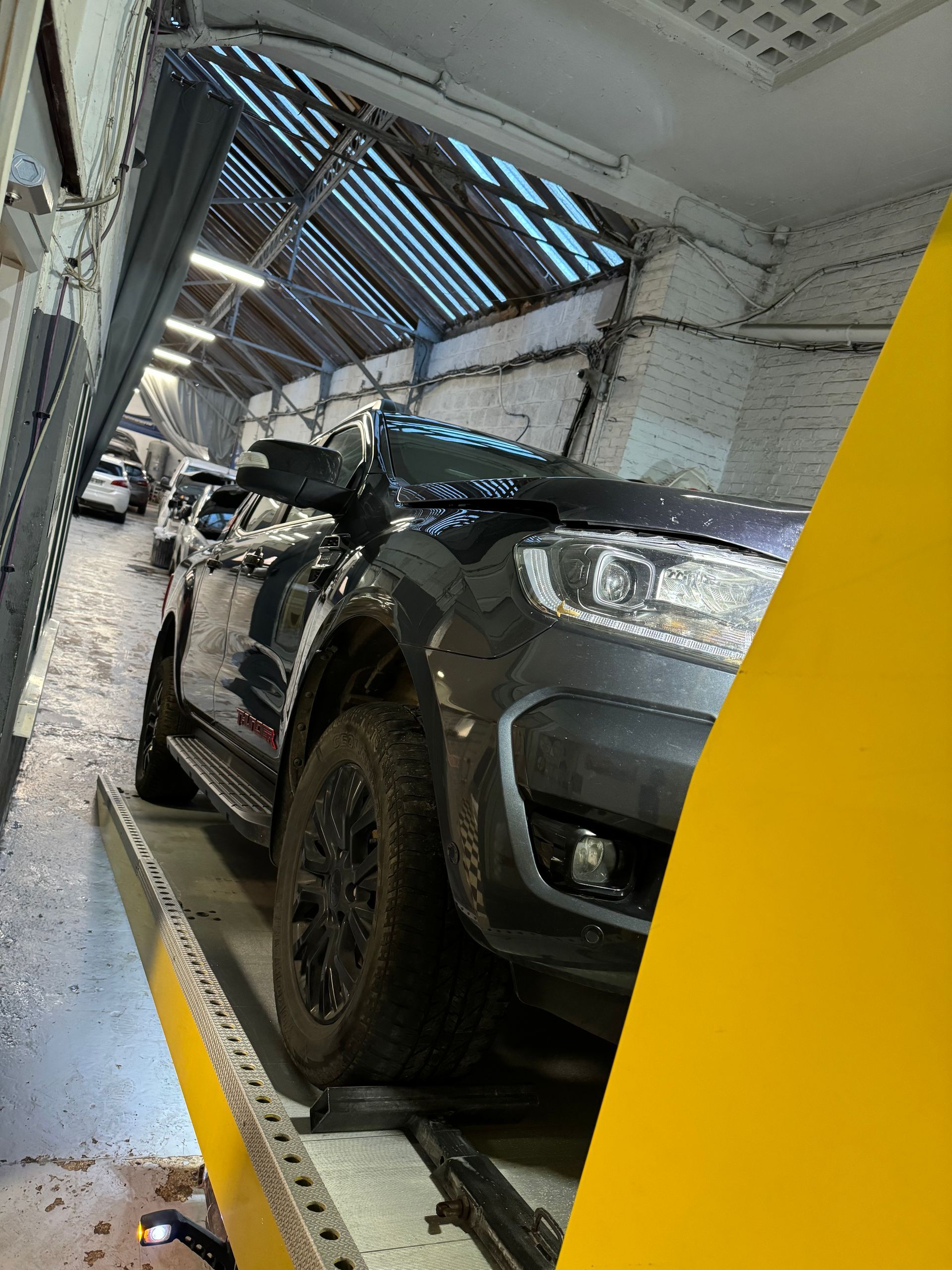 Voiture noire remorquée dans un garage auto