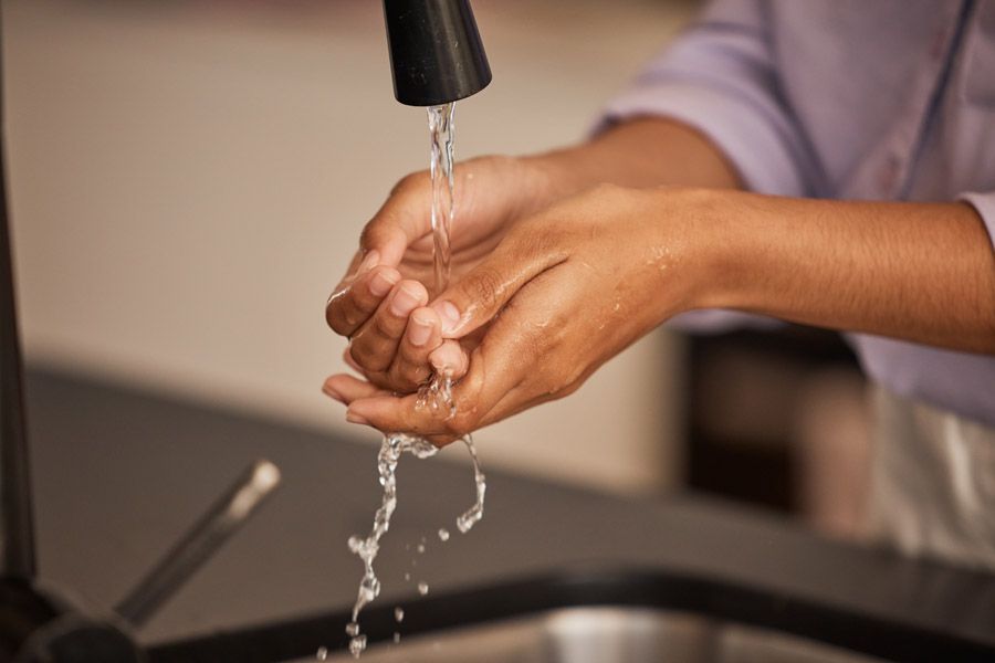 Femme qui se lave les mains avec de l'eau filtrée