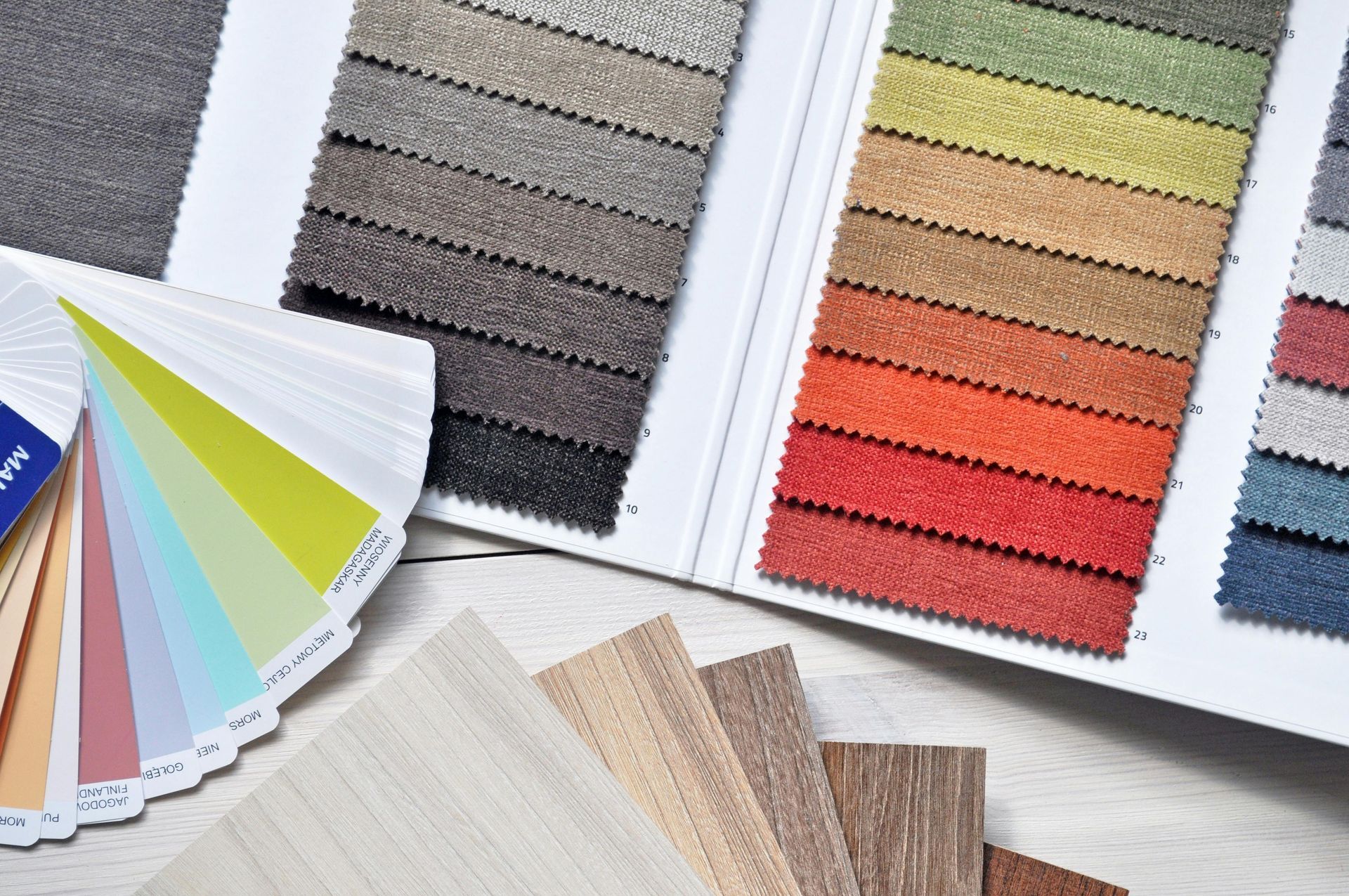 Muestras de color y muestras de tela dispuestas sobre una superficie blanca