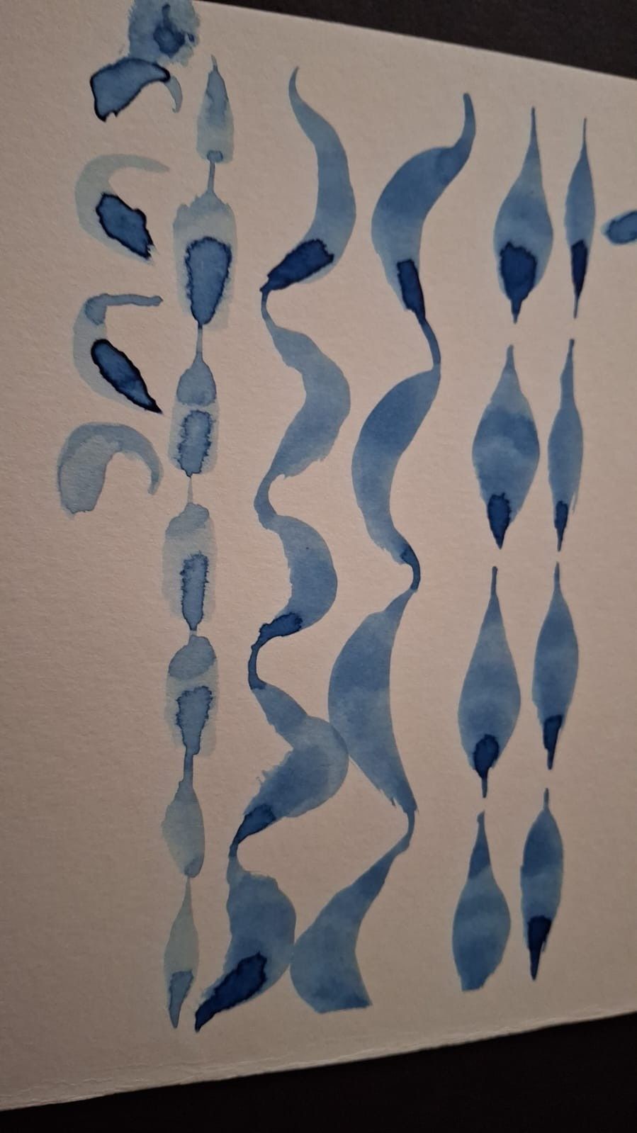 Una pequeña figurita de arcilla que representa a una bruja con un vestido morado y un sombrero negro montada en una escoba.