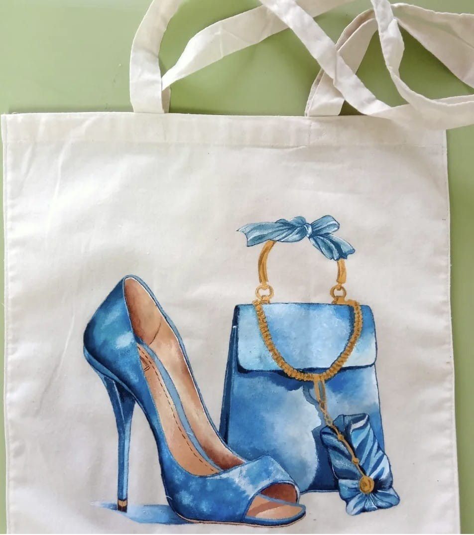 Una pequeña figurita de arcilla que representa a una bruja con un vestido morado y un sombrero negro montada en una escoba.