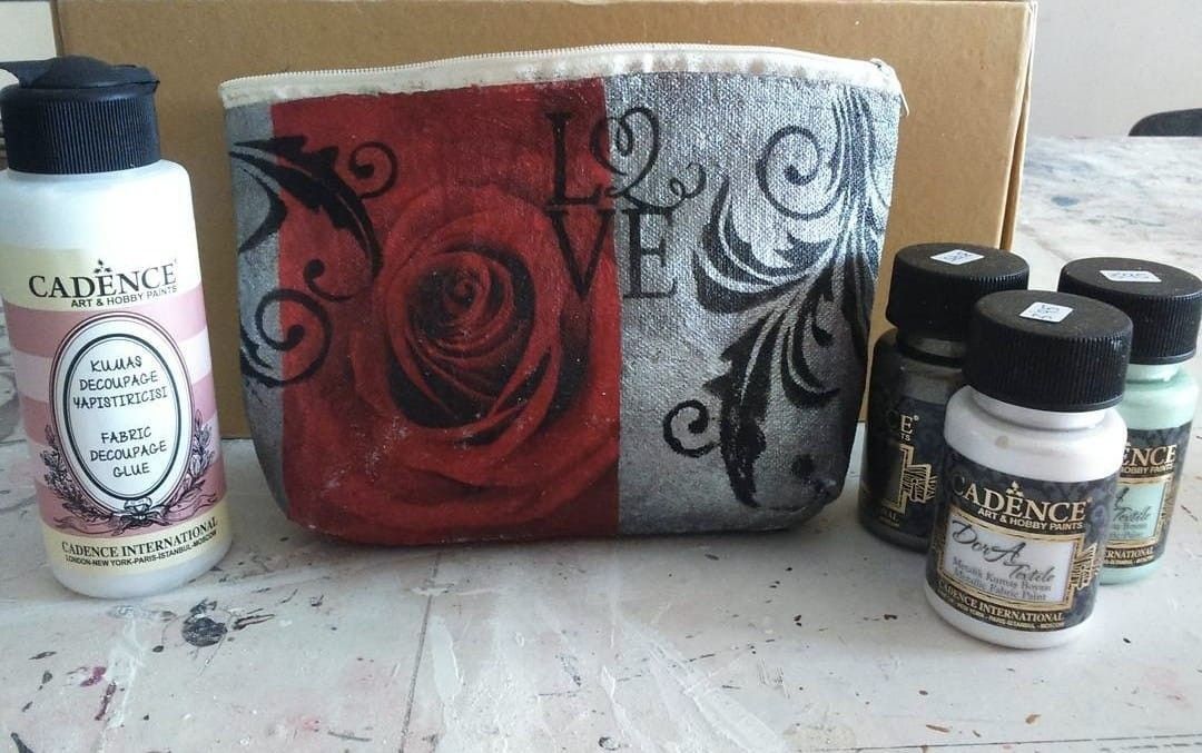 Una obra de arte enmarcada, realizada con técnica mixta, con una flor de alambre dorado metálico  sobre un fondo texturizado.