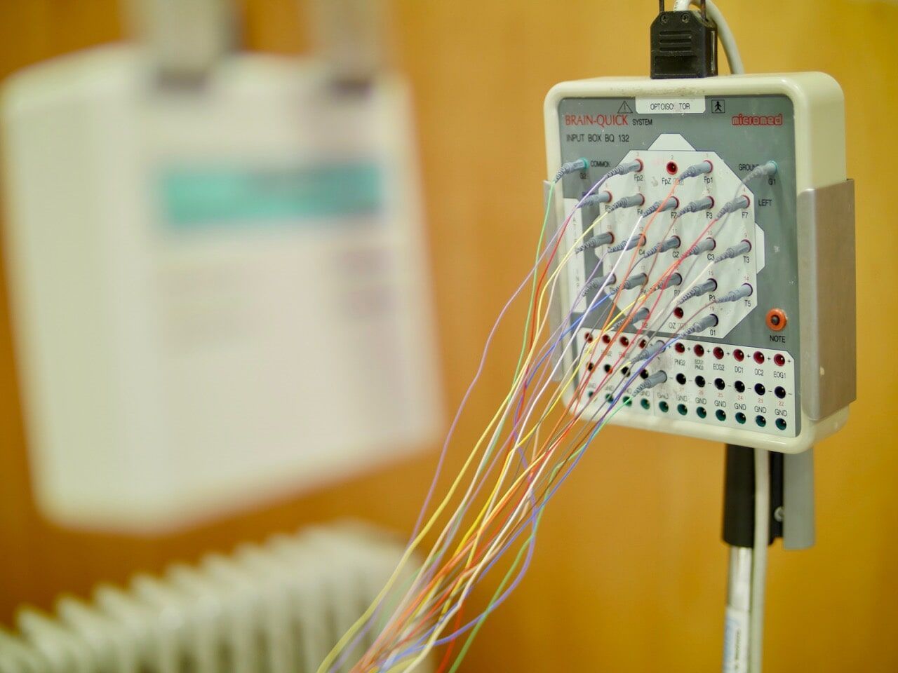 Imagem em close-up de um dispositivo médico com fios coloridos conectados a um painel.