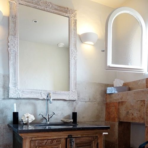 A bathroom with a large mirror above the sink