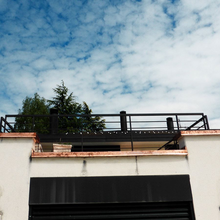 A balcony on top of a building with a blue sky in the background